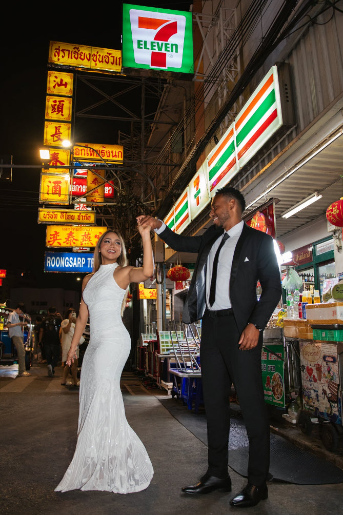 Couple in wedding formal attire dancing in front of a 7-Eleven store at night. Bangkok Chinatown Photoshoot by Photographer Nadya Shell